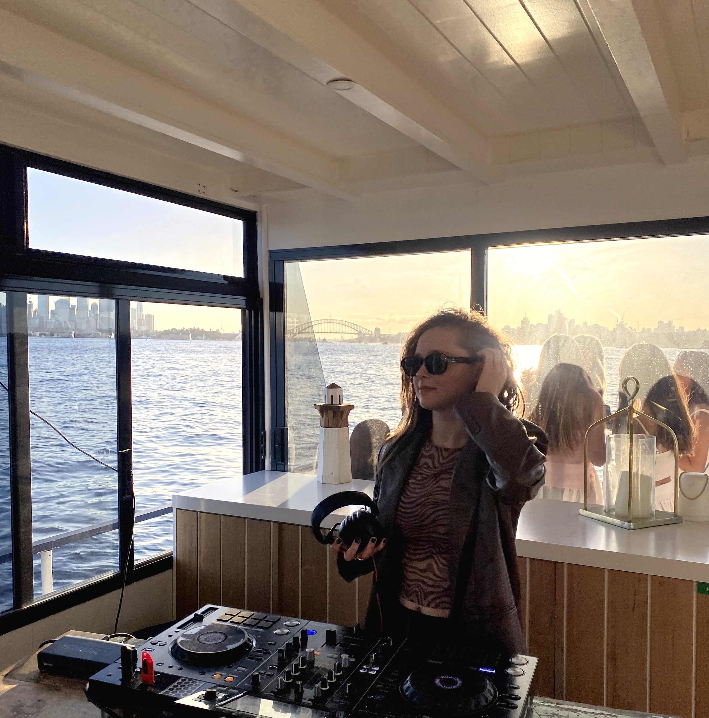 Mira Mira Collective performing at a waterfront event at sunset