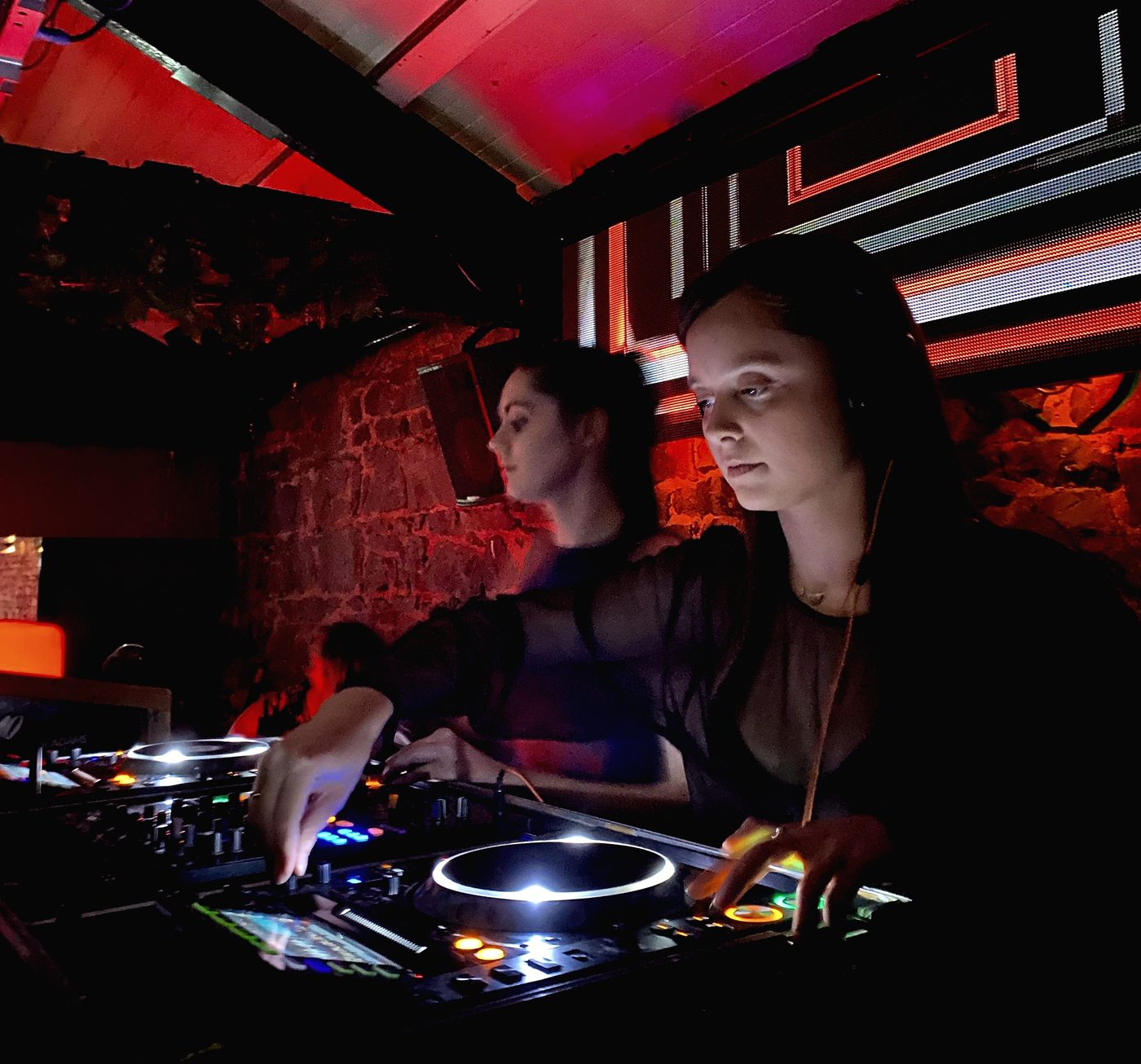Mira Mira Collective mixing together in a dark venue